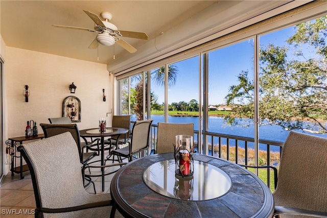 sunroom / solarium featuring a water view and ceiling fan