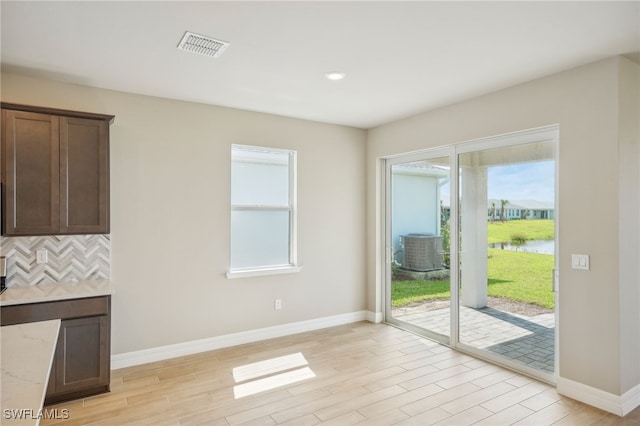 doorway to outside featuring light wood-type flooring and a water view