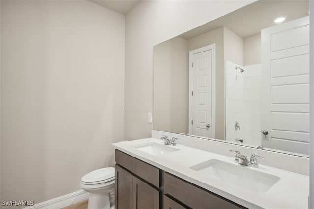 bathroom featuring walk in shower, vanity, and toilet