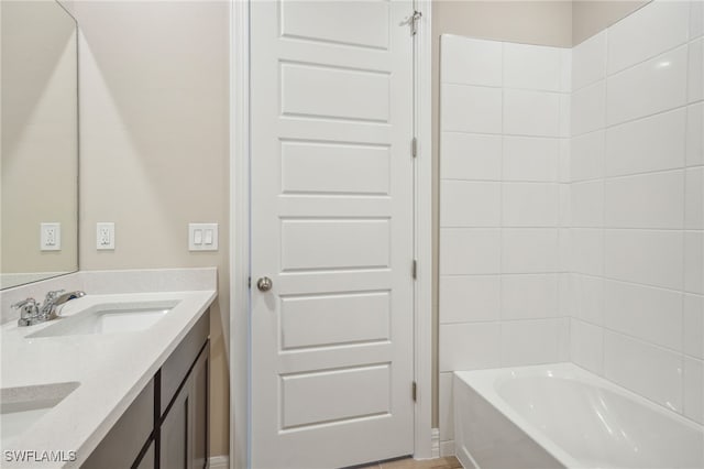 bathroom with tiled shower / bath and vanity