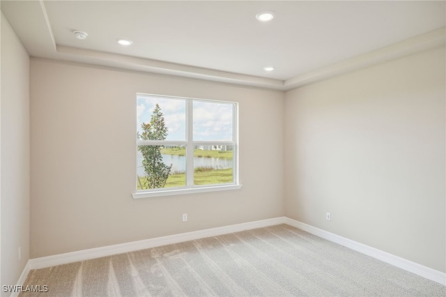 unfurnished room featuring carpet and a water view