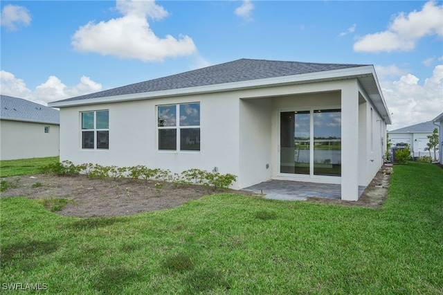 back of house featuring a patio and a yard