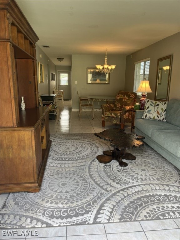 living room featuring a notable chandelier, light tile patterned flooring, and a wealth of natural light