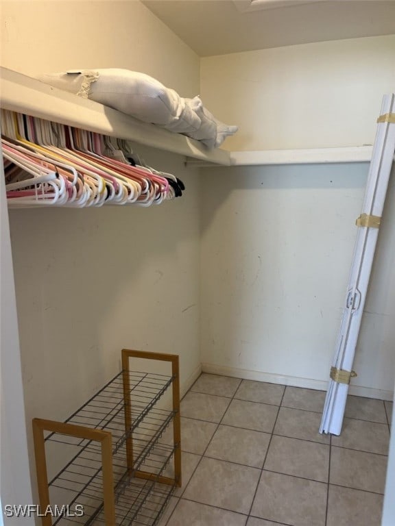 walk in closet with light tile patterned floors