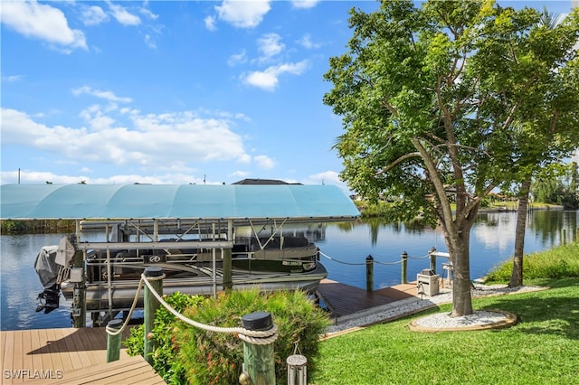 dock area featuring a water view, a yard, and boat lift