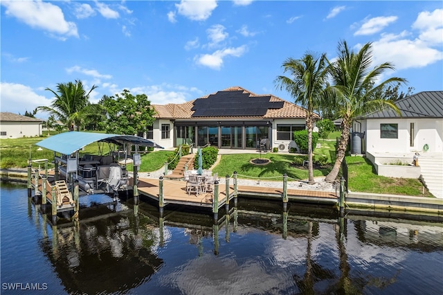 view of dock featuring a yard, a water view, and boat lift