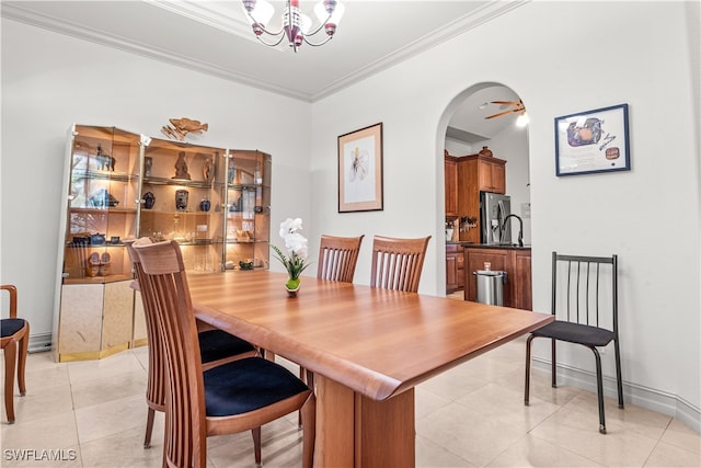 dining space featuring arched walkways, crown molding, light tile patterned floors, an inviting chandelier, and baseboards