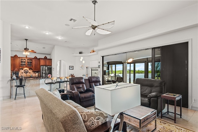 living area featuring light tile patterned floors, recessed lighting, visible vents, a water view, and ceiling fan