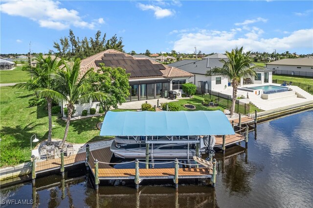 dock area with a fenced in pool, boat lift, a water view, a lawn, and a fenced backyard