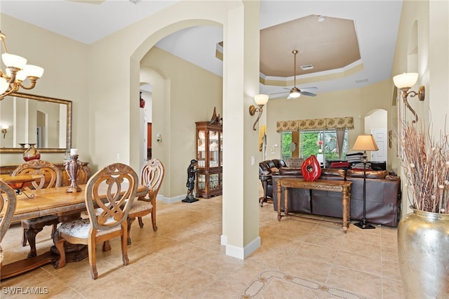 tiled dining room with ceiling fan with notable chandelier and crown molding