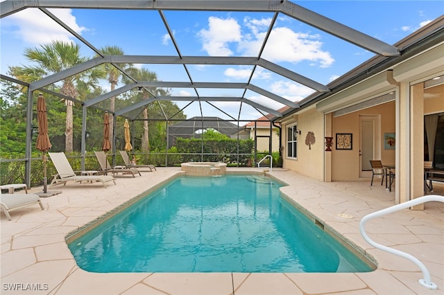 view of pool with an outdoor hot tub, a lanai, and a patio