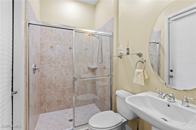 bathroom with sink, an enclosed shower, and toilet