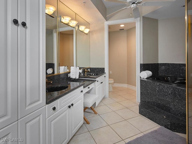 bathroom featuring ceiling fan, toilet, a washtub, vanity, and tile patterned flooring