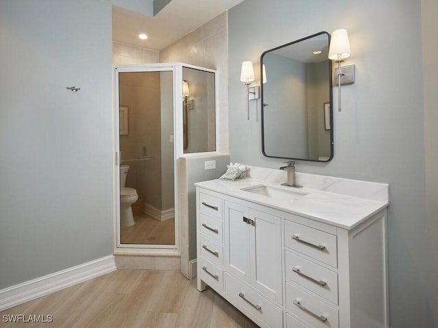 bathroom featuring toilet, walk in shower, vanity, and wood-type flooring