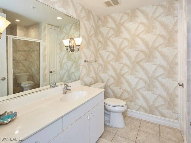 bathroom with vanity, tile patterned flooring, toilet, and walk in shower