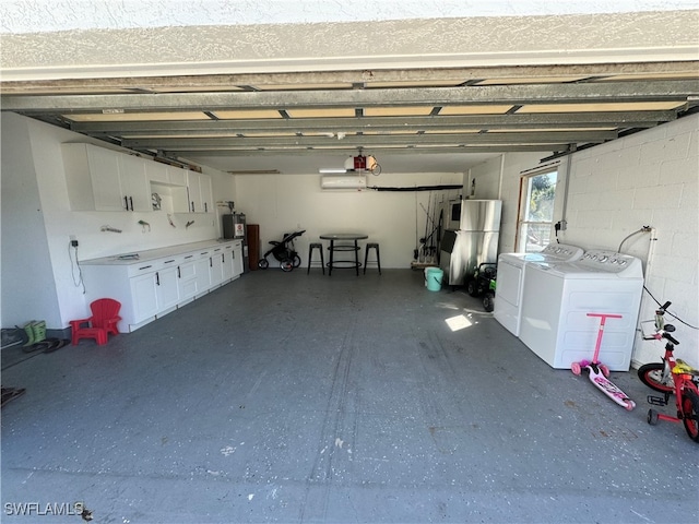 garage with stainless steel refrigerator and independent washer and dryer