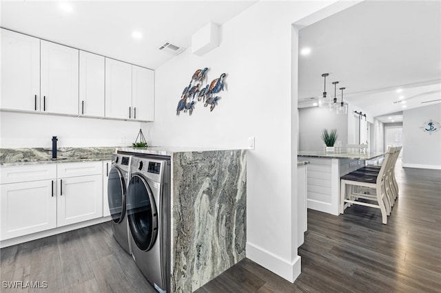 laundry room with separate washer and dryer, dark hardwood / wood-style flooring, sink, and cabinets