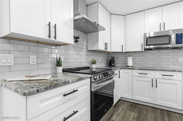 kitchen with dark hardwood / wood-style floors, white cabinets, wall chimney exhaust hood, stainless steel appliances, and decorative backsplash