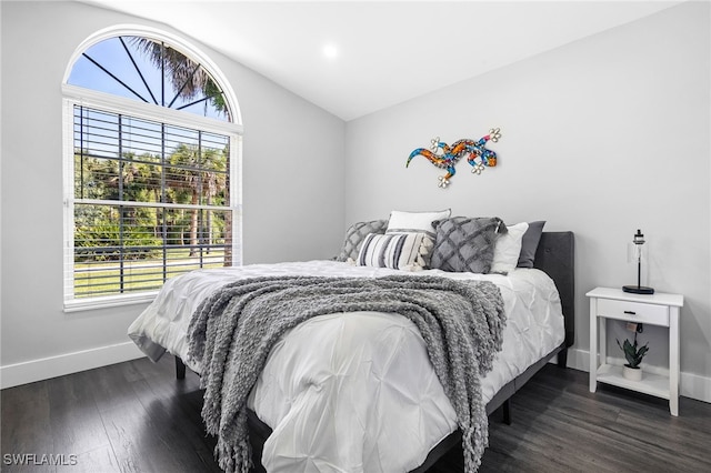 bedroom featuring dark hardwood / wood-style floors, vaulted ceiling, and multiple windows