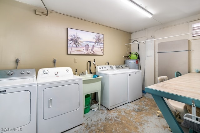 laundry room with water heater and washing machine and dryer