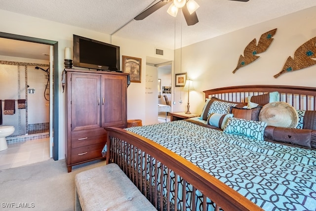 carpeted bedroom with ceiling fan, ensuite bathroom, and a textured ceiling