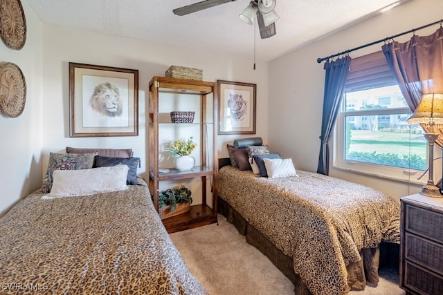 carpeted bedroom with ceiling fan and a textured ceiling