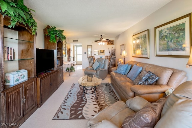 carpeted living room with a textured ceiling and ceiling fan