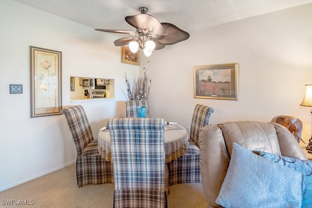 carpeted dining room featuring ceiling fan and a textured ceiling