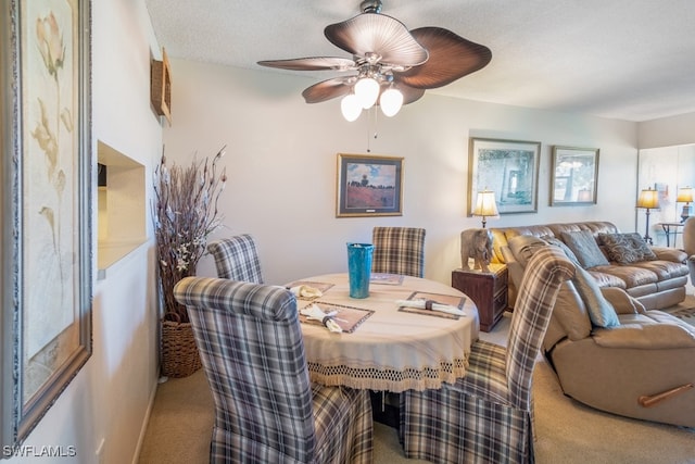 dining area with carpet floors, a textured ceiling, and ceiling fan