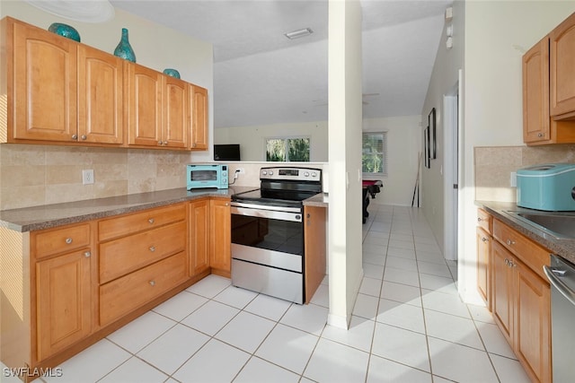 kitchen featuring stainless steel appliances, backsplash, and light tile patterned floors