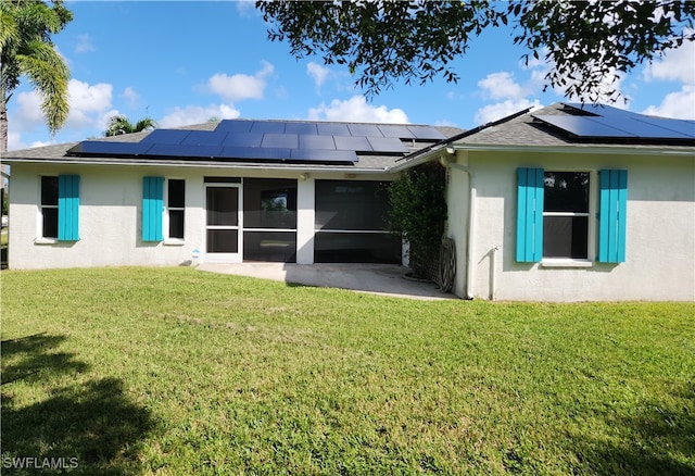 rear view of property featuring solar panels, a yard, and a sunroom