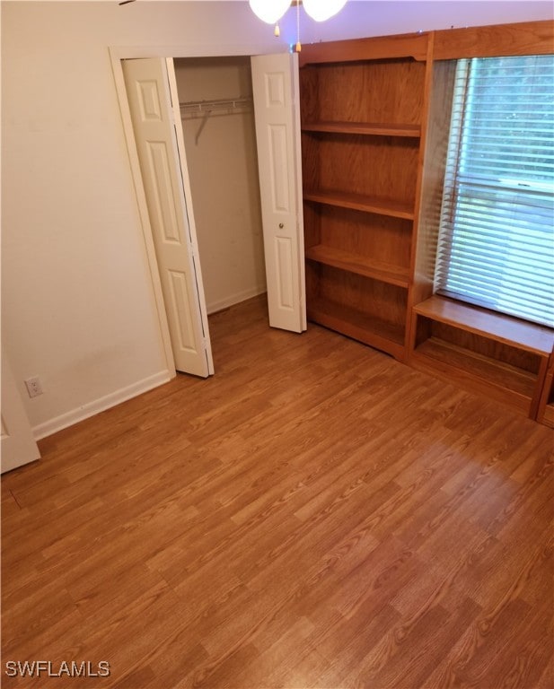 unfurnished bedroom with hardwood / wood-style flooring and a closet