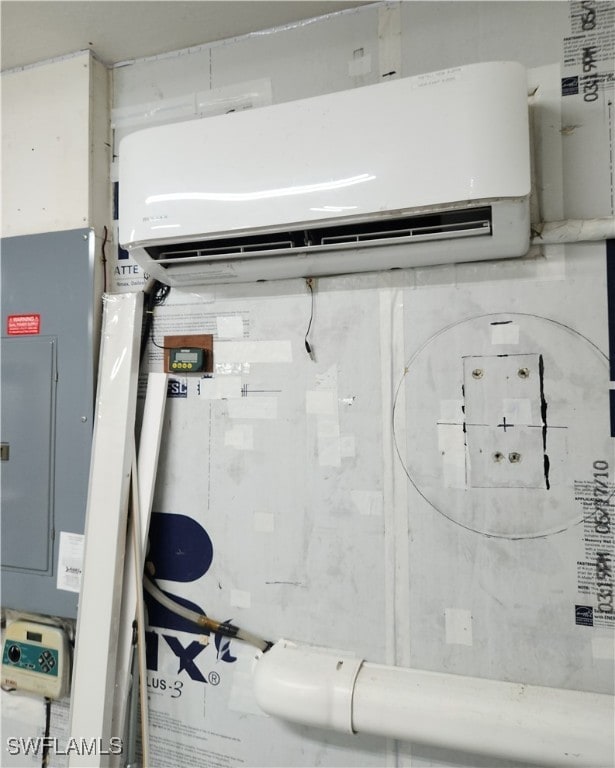 utility room with electric panel and a wall mounted air conditioner