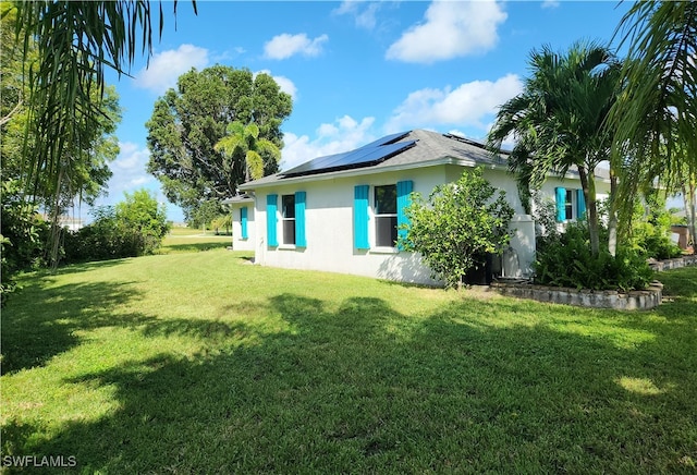 view of property exterior featuring solar panels and a lawn