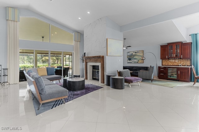 tiled living room featuring lofted ceiling, ceiling fan, and a fireplace