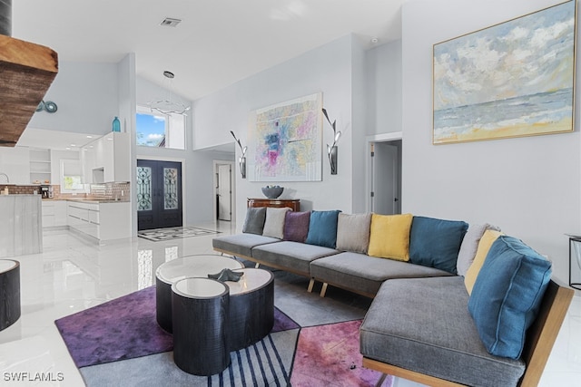 living room featuring light tile patterned floors, french doors, and high vaulted ceiling