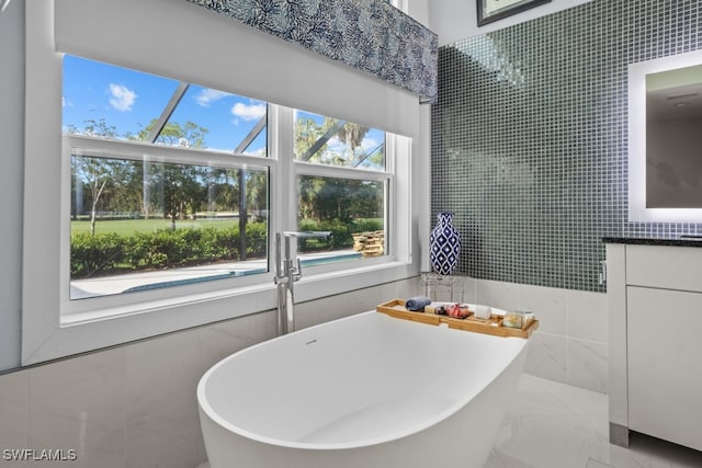 bathroom featuring tile walls, a washtub, and vanity