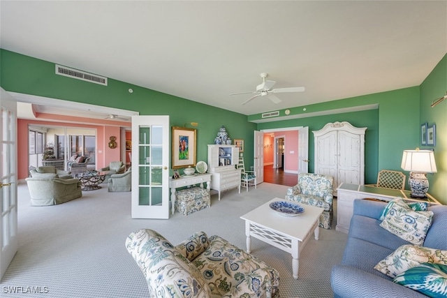 carpeted living room with french doors and ceiling fan