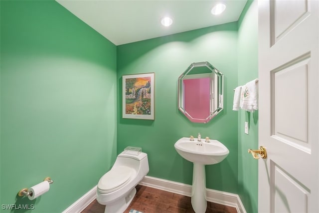 bathroom featuring hardwood / wood-style flooring and toilet