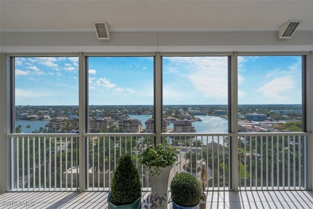 unfurnished sunroom featuring a wealth of natural light and a water view