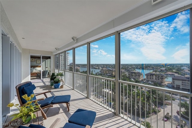 sunroom featuring a wealth of natural light and a water view