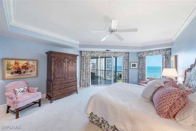 carpeted bedroom with a water view, crown molding, ceiling fan, access to exterior, and a tray ceiling