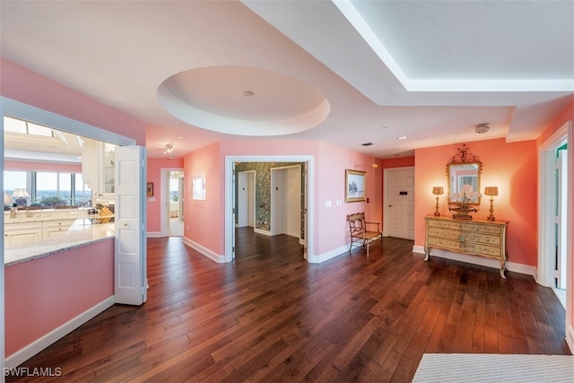 hall with dark hardwood / wood-style flooring and a raised ceiling