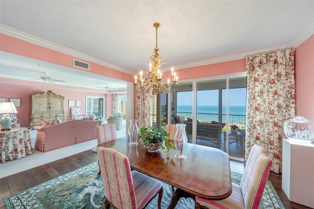 dining room with dark hardwood / wood-style flooring, a water view, ornamental molding, and ceiling fan with notable chandelier