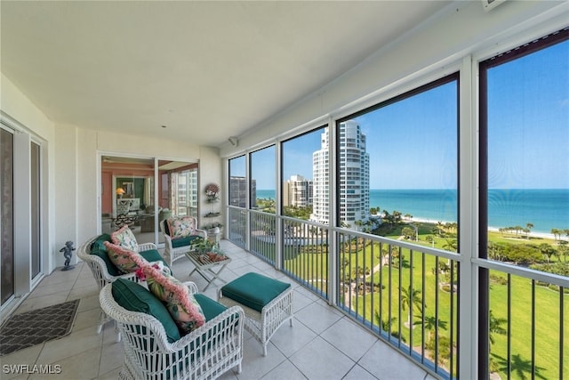 sunroom featuring a water view