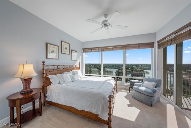 carpeted bedroom with access to outside, a water view, and ceiling fan