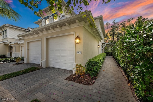 property exterior at dusk featuring a garage