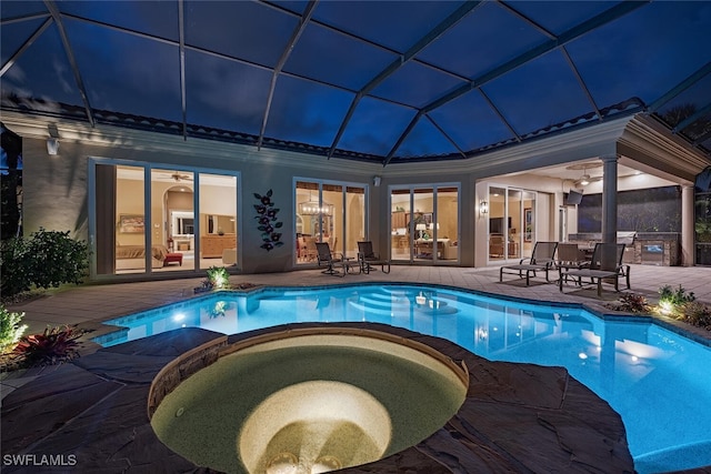 view of swimming pool with glass enclosure, an in ground hot tub, and a patio area