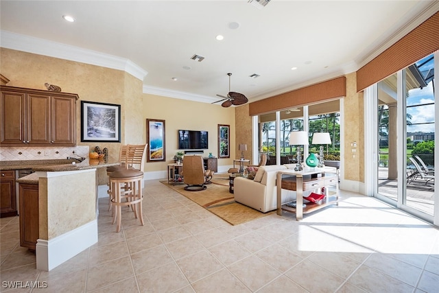 tiled living room with ceiling fan and crown molding