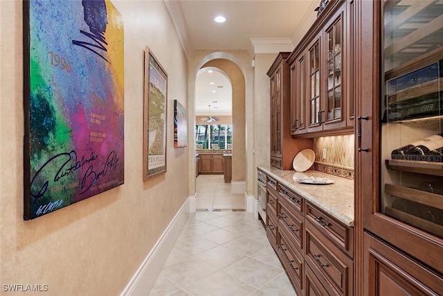 hallway featuring light tile patterned flooring and crown molding